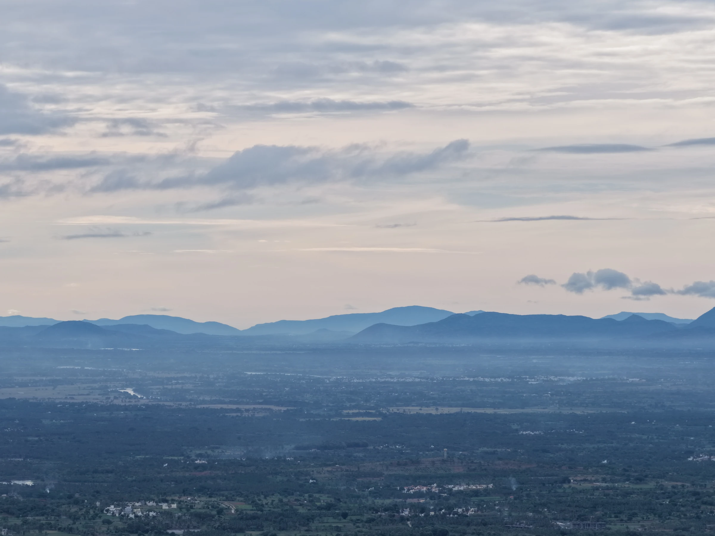Layered blue hills and the landscape below, photographed by Mamathesh Gowda