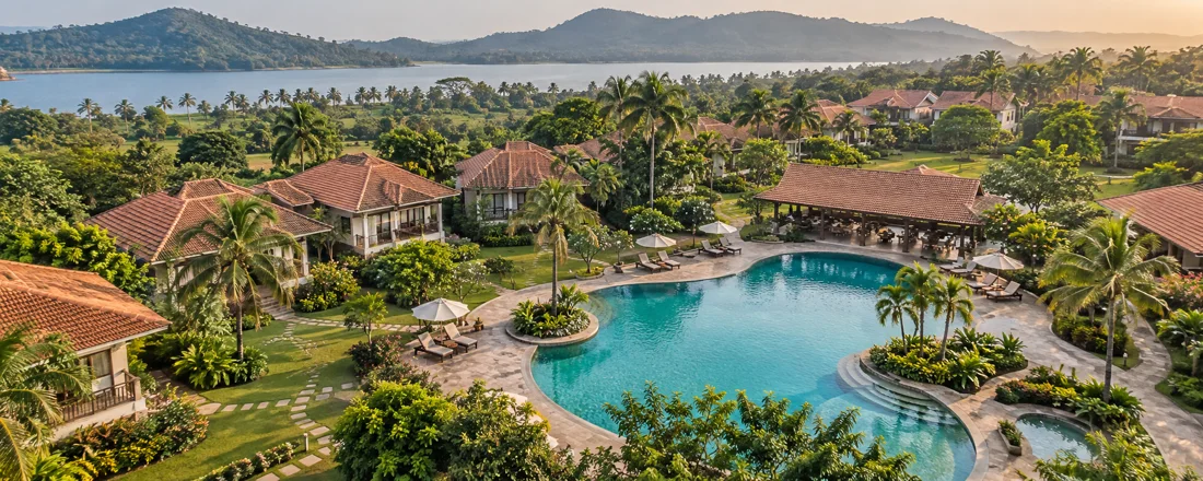 Illustrative aerial view of a resort with pool, cottages and palms.